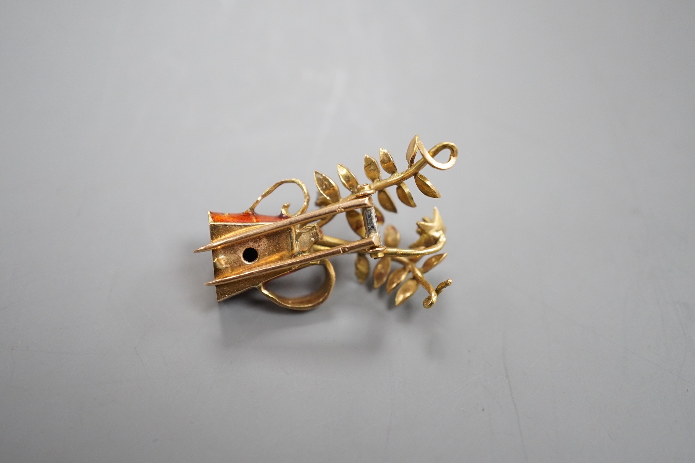 A French yellow metal (18ct poincon mark), two colour enamel, ruby and diamond set novelty brooch, modelled as a tyg with foliate stems, signed Marcel Pac, Paris, 29mm, gross weight 5.8 grams.